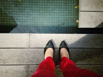 Low section of woman standing at poolside