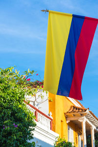 Low angle view of colombian flag against blue sky