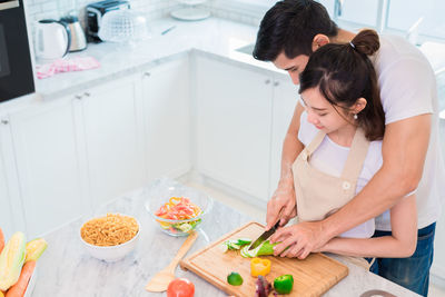 High angle view of couple preparing food in kitchen