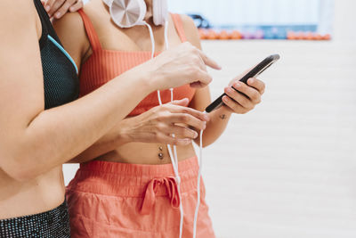 Midsection of women using mobile phone