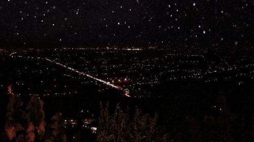 Low angle view of illuminated city against sky at night