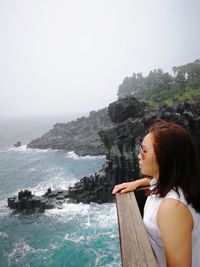 Woman looking at sea against clear sky