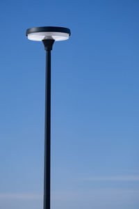 Low angle view of street light against blue sky