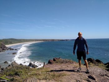 Full length of man standing at cliff against sea