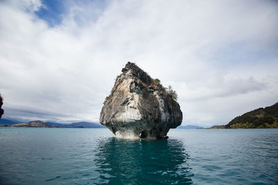 Rock formation in sea against sky