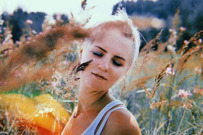 Close-up of young woman with eyes closed by plants