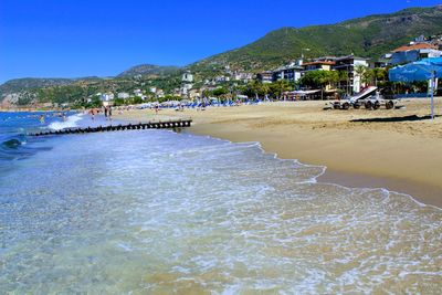 Scenic view of beach against clear blue sky