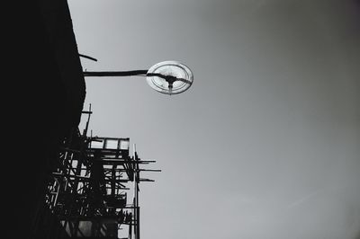 Low angle view of silhouette cranes against clear sky