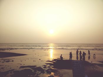 Scenic view of beach against clear sky during sunset