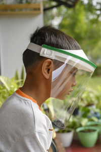 A young asian boy wearing face shield to stay safe and healthy in the pandemic covid