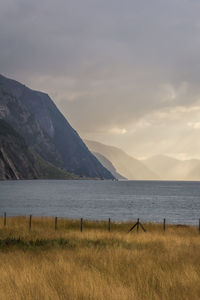 Scenic view of fjord and mountains against sky