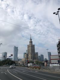 Vehicles on road against buildings in city