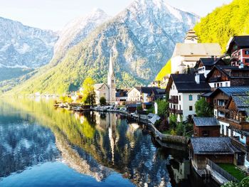 Scenic view of lake by buildings against mountains