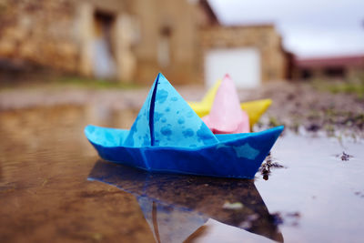 Close-up of multi colored paper boats floating on water