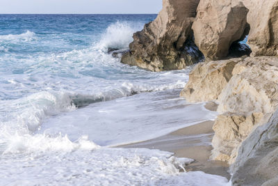 Scenic view of rocks on beach against sky