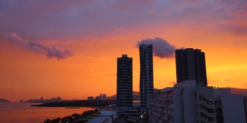 Modern buildings against sky during sunset