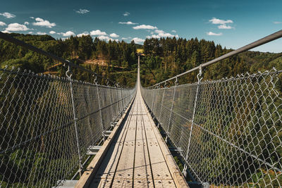 Bridge over empty road against sky