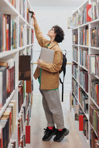 Rear view of man standing in library