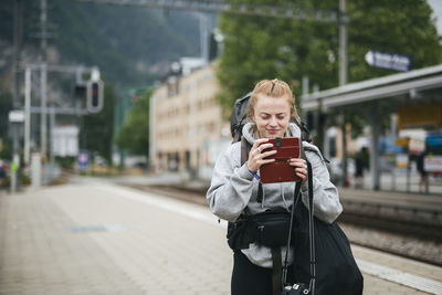 Woman using cell phone on train station