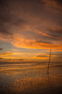 Scenic view of beach against orange sky