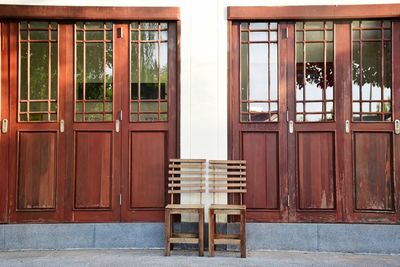 Empty chairs and tables against building