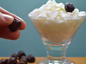 Close-up of hand holding jojoba see by flakes in glass