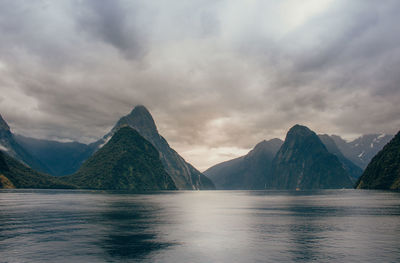 Scenic view of lake by mountains against sky