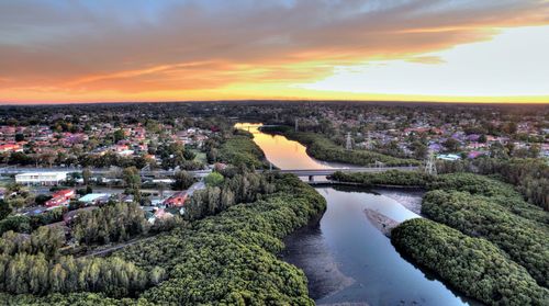 Aerial view of city by sea against sky