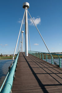 View of suspension bridge against blue sky