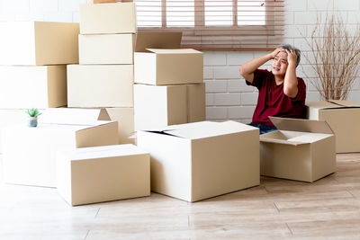 Full length of woman sitting in box