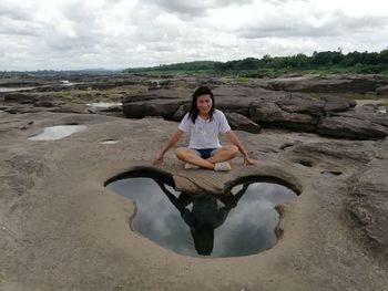 Portrait of man sitting on rock