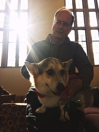 Portrait of man with dog at home