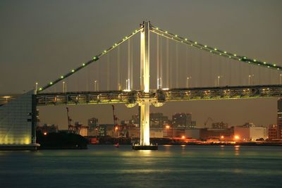 View of suspension bridge in city at night