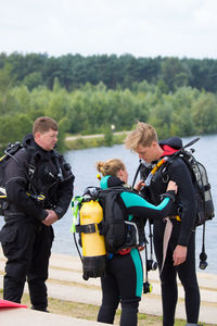 People preparing for scuba diving by lake
