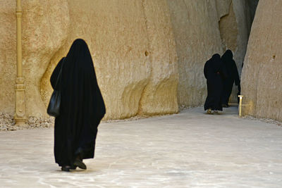 Rear view of women wearing burka against built structure