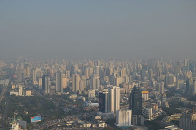 Aerial view of buildings in city against clear sky