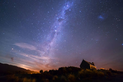 Low angle view of silhouette building against sky at night