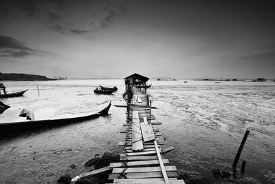 Broken pier over sea against sky at beach