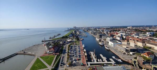 High angle view of buildings by sea against clear sky