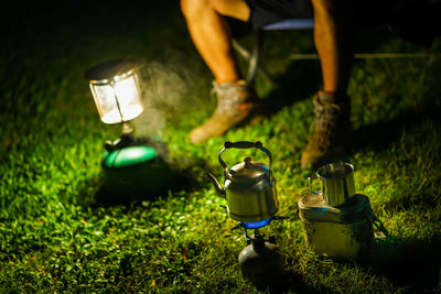 Low section of man standing on grass at night