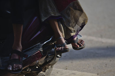 Low section of man sitting on street