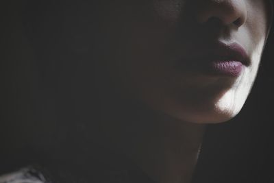 Close-up midsection of young woman in dark