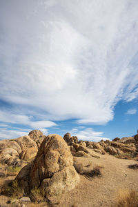 Rock formations on desert land against sky