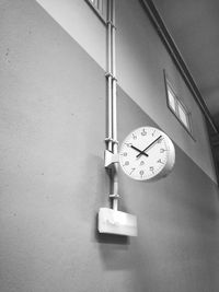 Low angle view of clock hanging on wall