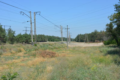 Electricity pylon on field against clear sky