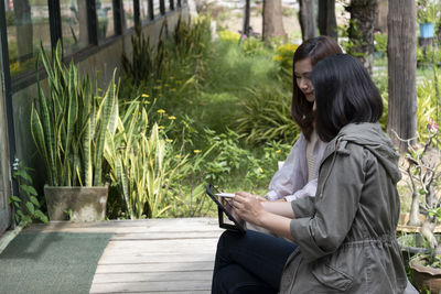 Side view of woman using tablet in park.