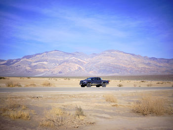 A toyota truck parked on the side of a desert highway, death valley.