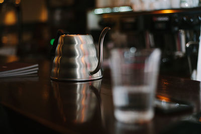 Drinking glass and container on table