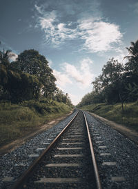 Surface level of railroad tracks against sky.