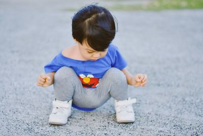 Side view of cute girl playing with toy on floor